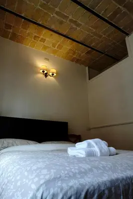 a bedroom with a white bed with a ceiling at Steps from the Vatican Guesthouse in Rome