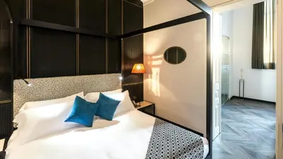 a bedroom with a black and white bed with blue pillows at Hotel The Haven Roma in Rome