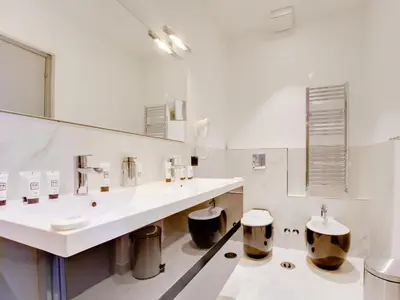 a white bathroom with two sinks and a mirror at Queen Palace Suites in Rome