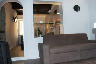a living room with a brown couch and a hallway at SuityRHome RioneMonti118 in Rome