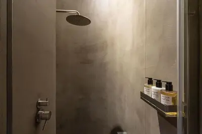 a bathroom with a shower with three bottles on a shelf at Hotel dei Barbieri in Rome