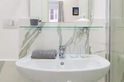 a bathroom sink with a glass shelf above it at Little Aurelius in Rome