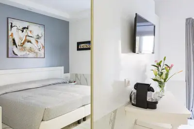 a bedroom with a white bed and a mirror at Little Aurelius in Rome