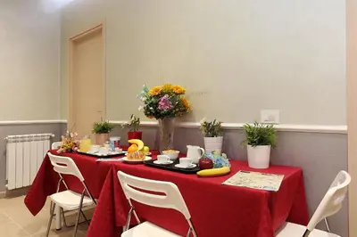 a table with a red table cloth and flowers on it at AdoraSuite 2 in Rome