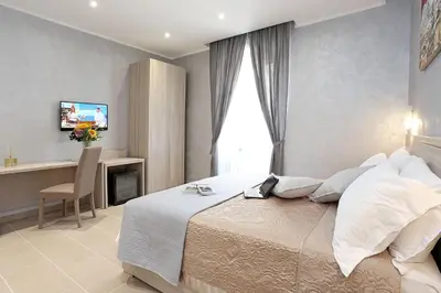 a bedroom with a bed and a desk and a television at AdoraSuite 2 in Rome