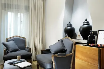 a room with two chairs and a desk and a window at Mario De' Fiori 37 in Rome
