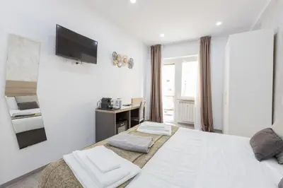 a white bedroom with a bed and a mirror at 247 Luxury Rooms Trastevere in Rome