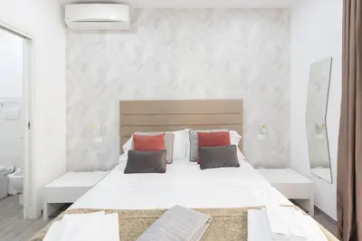 a white bedroom with a large white bed with pillows at 247 Luxury Rooms Trastevere in Rome
