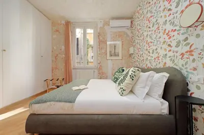 a bedroom with a bed with a floral wall at Casa Navona - My Extra Home in Rome