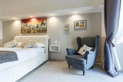 a bedroom with a bed and a chair at Sallustio Fine Rooms Guest House in Rome