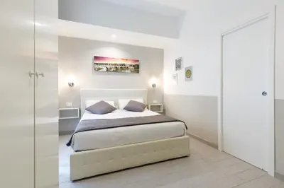 a white bedroom with a bed and a sliding glass door at Sallustio Fine Rooms Guest House in Rome