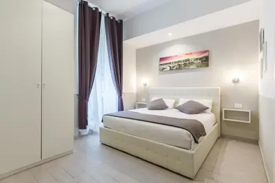 a bedroom with a bed and a large window at Sallustio Fine Rooms Guest House in Rome