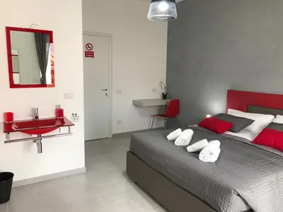 a bedroom with a bed with red and white pillows at Dunant House in Rome