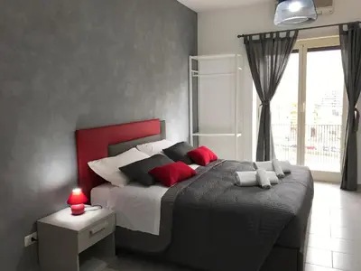 a bedroom with a large bed with red pillows at Dunant House in Rome