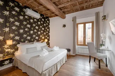 a bedroom with a bed with a floral wall at i Fiori de' Mario Suites in Rome