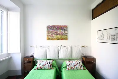 a bedroom with a green bed with two pillows at L'architetto in Rome