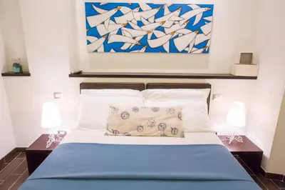 a bedroom with a bed with two lamps and a painting at Bbqueen in Rome