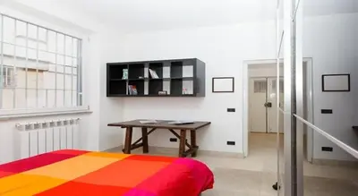 a bedroom with a bed and a desk and a window at Parioli House near Borghese-LUISS University in Rome