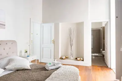 a white bedroom with a bed and a bathroom at Campo Marzio Boutique in Rome