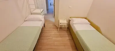 two beds in a hospital room with a table at Bed&BikeRome ROOMS in Rome