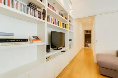 a living room with white shelves and a tv at Micol's Place, bright apt 2 rooms, 2 toilets, near metro, 80 mq in Rome