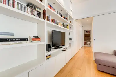 a living room with white shelves and a tv at Micol's Place, bright apt 2 rooms, 2 toilets, near metro, 80 mq in Rome