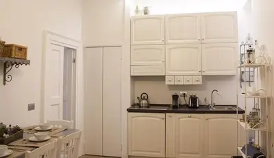 a white kitchen with white cabinets and a sink at Splendid House In Trastevere in Rome