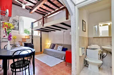 a small apartment with a loft bed and a table and chairs at Pretty Flat Trastevere in Rome