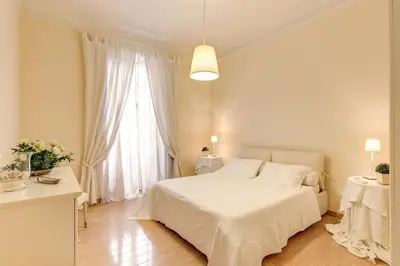 a white bedroom with a white bed and a window at RHH Rome Holiday Home in Rome