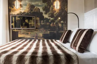 a bedroom with a bed with a painting on the wall at Hotel Palazzo Manfredi – Small Luxury Hotels of the World in Rome