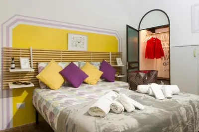 a bedroom with a large bed with colorful pillows at STELLA'S APARTMENT IN MONTI in Rome