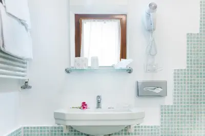 a white bathroom with a sink and a mirror at Domus Popolo in Rome