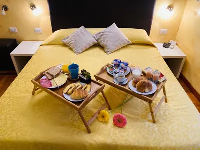 a bed with two tables with breakfast foods on it at Domus Popolo in Rome
