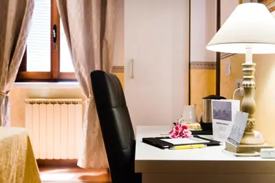 a bedroom with a desk with a lamp and a chair at Domus Popolo in Rome