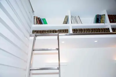 a ladder leading up to a white shelf with books at Relais Dolcevita in Rome