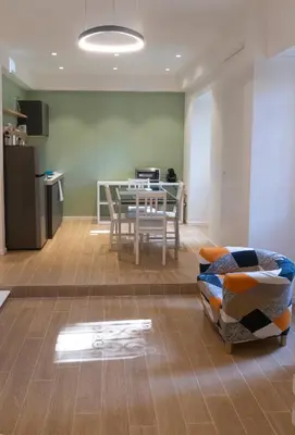 a living room with a table and a kitchen at Flaminio New Apartment in Rome