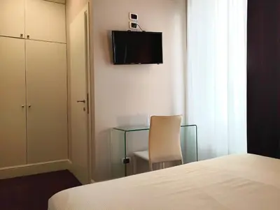 a bedroom with a desk and a chair and a television at Guest House Cavour 278 in Rome