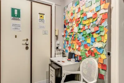a room with a desk and a wall covered in notes at Guest House Cavour 278 in Rome