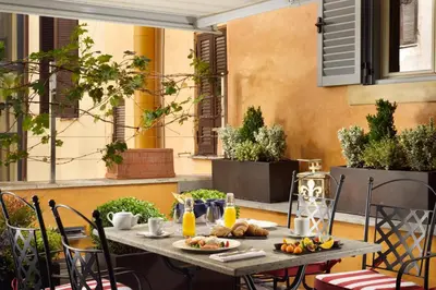 a table with food on it on a patio at Hotel De' Ricci - Small Luxury Hotels of the World in Rome