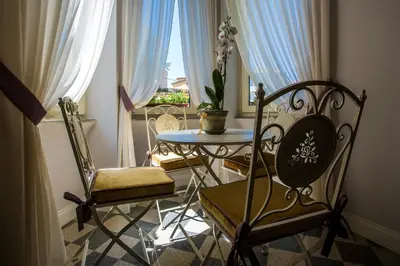 a room with a table and two chairs and a window at Trastevere Royal Suite in Rome
