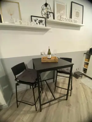 a dining room table with two chairs and a bottle of wine at Diecipassi dal Colosseo in Rome