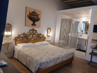 a bedroom with a king sized bed and a bathroom at Excellent Trinity Rooms in Rome