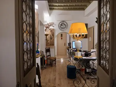 a living room with a table and a clock on the wall at Excellent Trinity Rooms in Rome