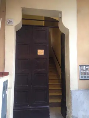 a large black door in a building with stairs at Attico incantevole, Pìgneto Roma in Rome