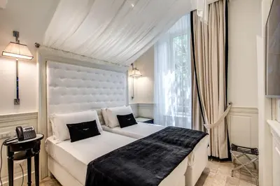 a bedroom with a large white bed and a window at Hotel dei Quiriti Suite in Rome
