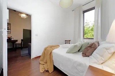 a white bedroom with a bed and a window at Tevere apartments in Rome