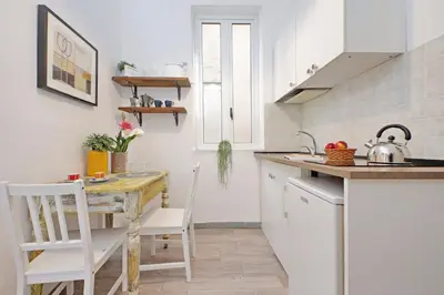 a kitchen with a table and chairs and a kitchen with white cabinets at Tevere apartments in Rome
