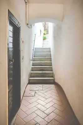 a hallway with stairs with a door and a stair case at Vicoloft Vicolo in Rome