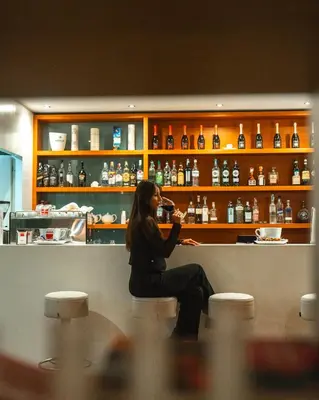 a woman sitting at a counter in a bar at Phi Hotel Garden Area Roma Eur in Rome