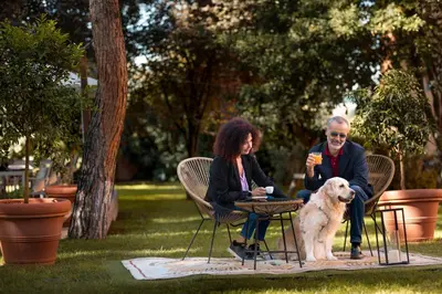a man and a woman sitting in chairs with a dog at Phi Hotel Garden Area Roma Eur in Rome